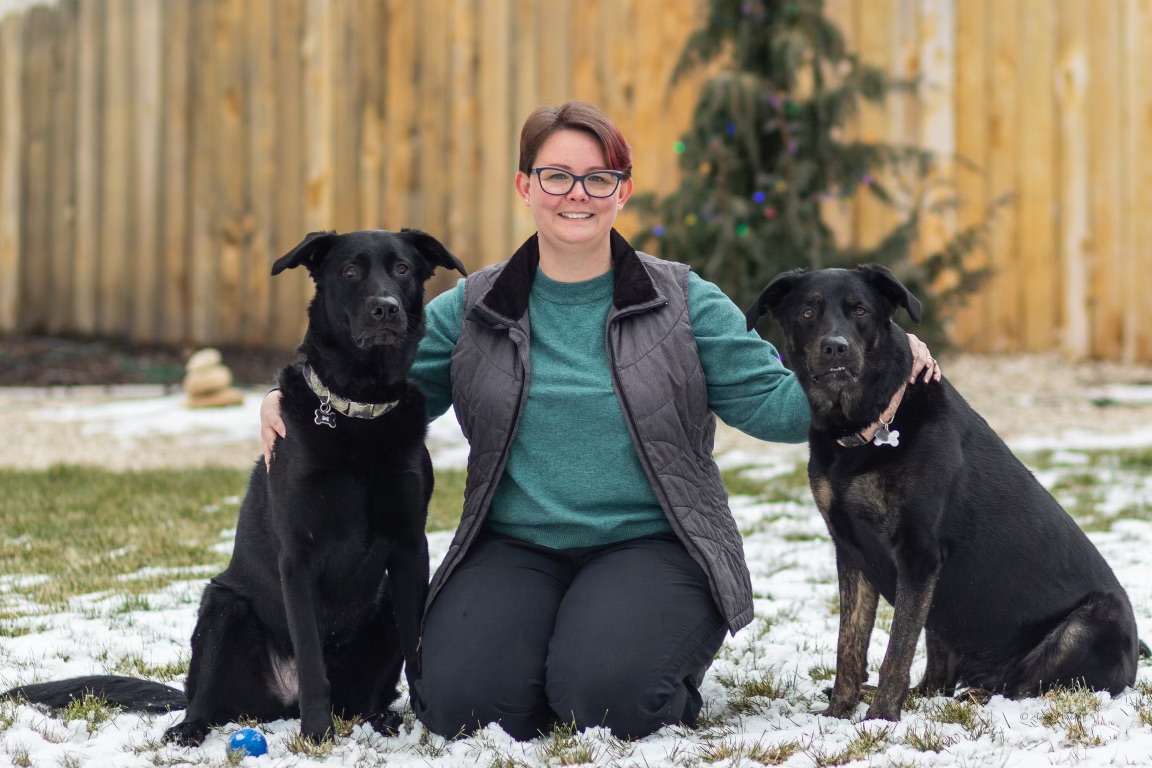 woman with two black dogs